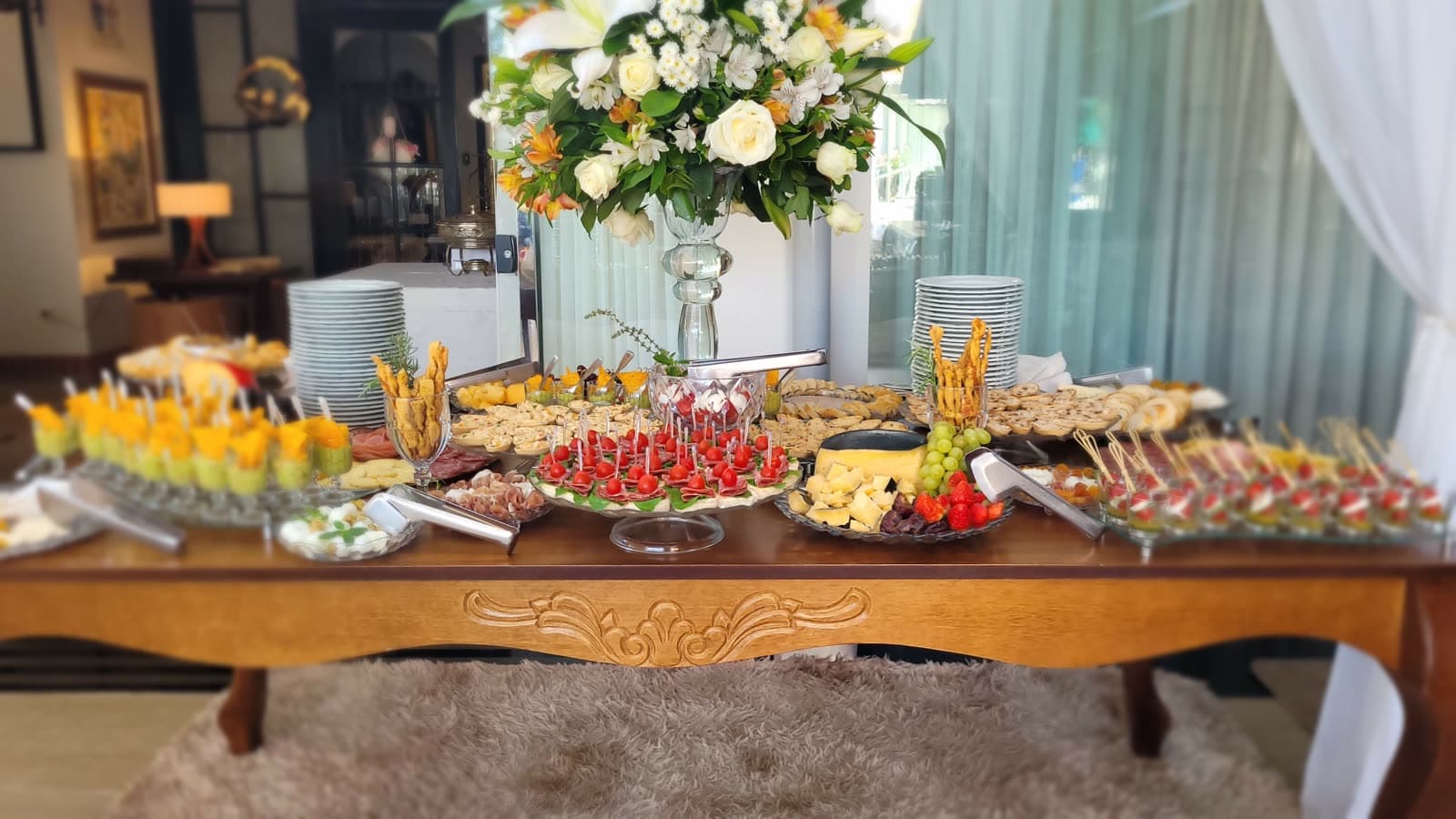 Mesa gastronômica com finger food, charcutaria e queijos